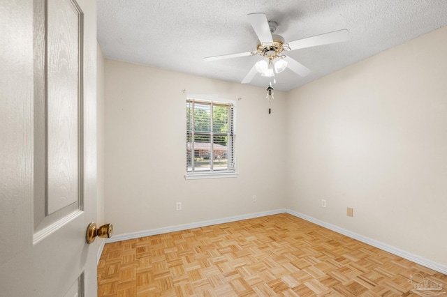 spare room featuring a textured ceiling, baseboards, and a ceiling fan
