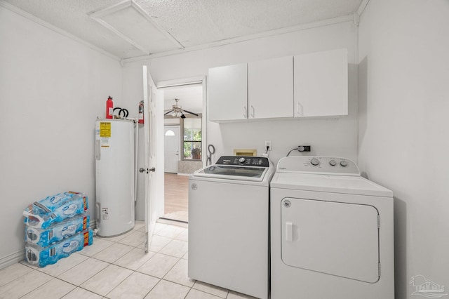 laundry room with light tile patterned floors, cabinet space, a textured ceiling, electric water heater, and independent washer and dryer