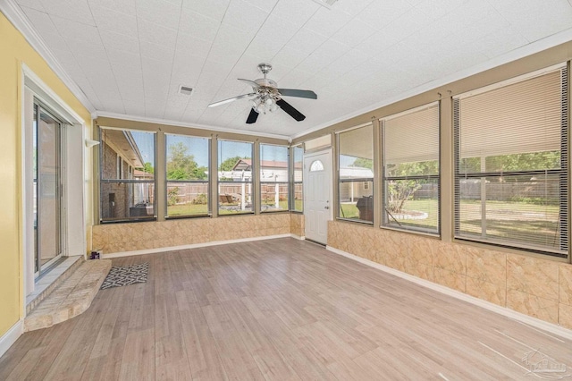 unfurnished sunroom featuring plenty of natural light, visible vents, and a ceiling fan