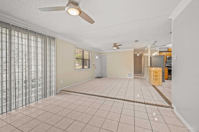 empty room with ornamental molding, light tile patterned flooring, a ceiling fan, and visible vents