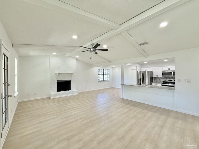 unfurnished living room featuring baseboards, recessed lighting, a ceiling fan, light wood-style floors, and vaulted ceiling with beams