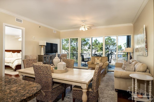 living room featuring ornamental molding, visible vents, and ceiling fan