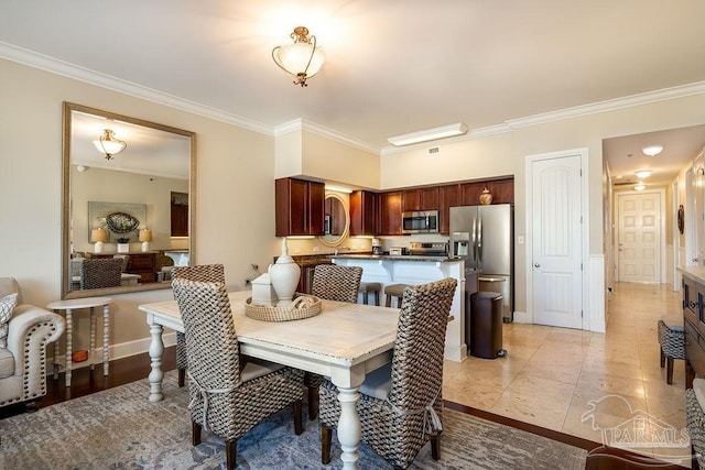 dining space featuring ornamental molding, baseboards, and light tile patterned floors