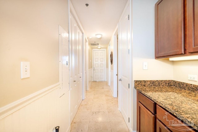 corridor featuring a wainscoted wall