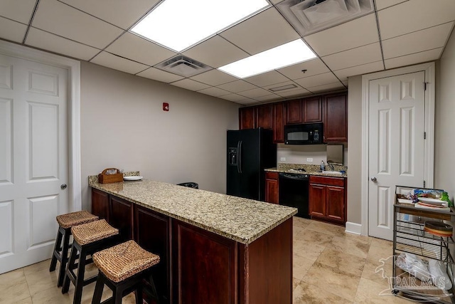 kitchen featuring a peninsula, black appliances, visible vents, and light stone counters