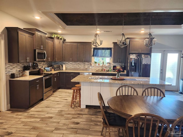 kitchen featuring pendant lighting, a kitchen breakfast bar, a kitchen island, and appliances with stainless steel finishes