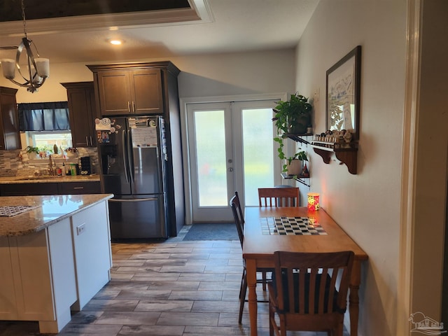 kitchen with french doors, sink, decorative light fixtures, stainless steel fridge, and dark brown cabinets