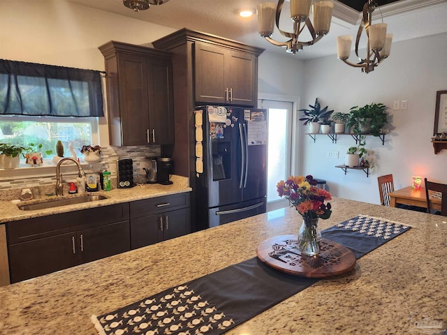 kitchen with refrigerator with ice dispenser, dark brown cabinets, a wealth of natural light, and sink