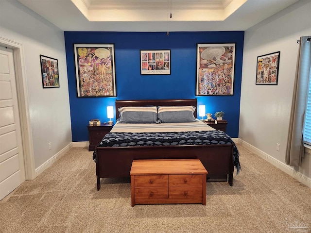 carpeted bedroom with a tray ceiling and crown molding