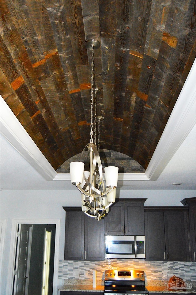 interior details featuring backsplash, ornamental molding, stainless steel appliances, and an inviting chandelier