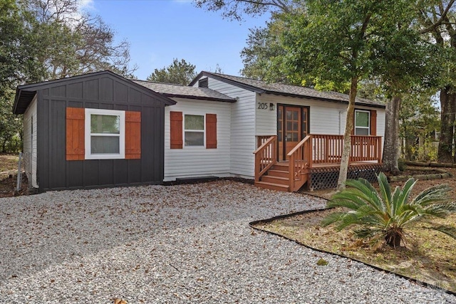 view of front of property with board and batten siding and gravel driveway