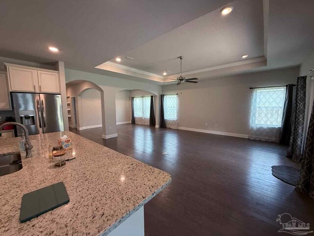 7912 Stream Ridge Rd, Pensacola, FL 32526 - kitchen with stainless steel fridge, arched walkways, a tray ceiling, a ceiling fan, and baseboards