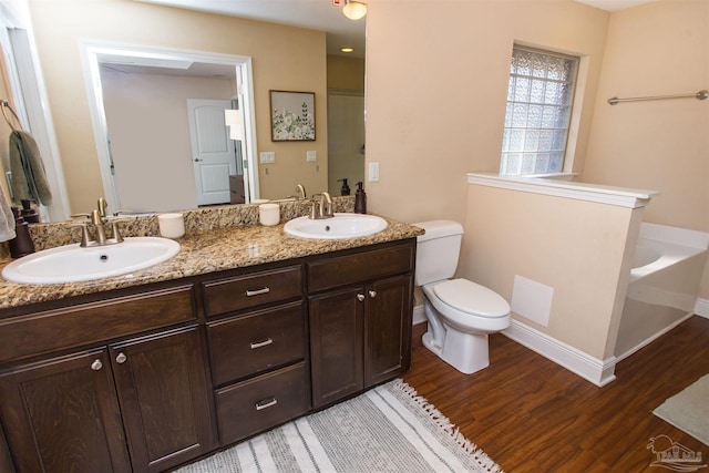 bathroom featuring toilet, a bathtub, vanity, and hardwood / wood-style flooring