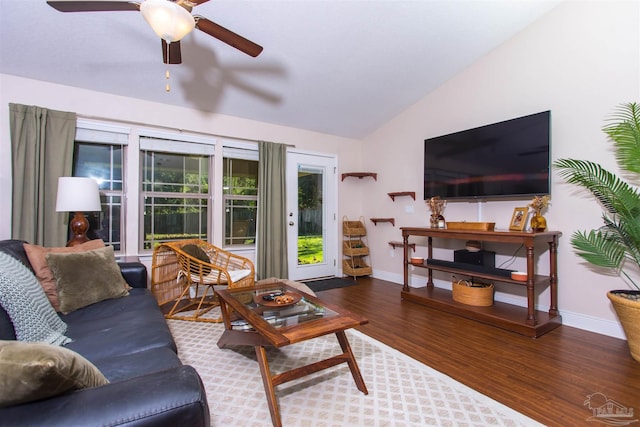 living room with ceiling fan, dark wood-type flooring, and vaulted ceiling