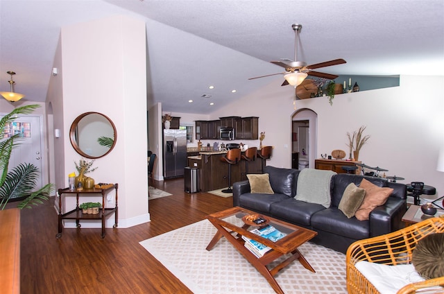 living room with a textured ceiling, dark hardwood / wood-style flooring, ceiling fan, and lofted ceiling