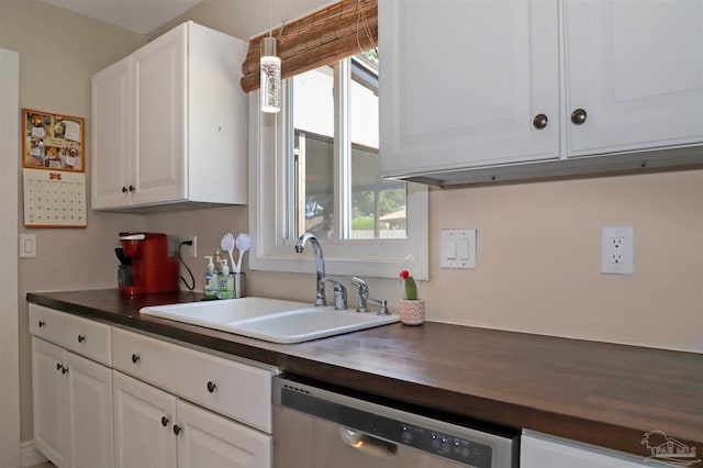 kitchen with dishwasher, butcher block counters, sink, pendant lighting, and white cabinetry