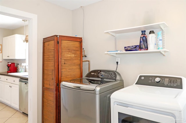 washroom with sink, light tile patterned flooring, and separate washer and dryer