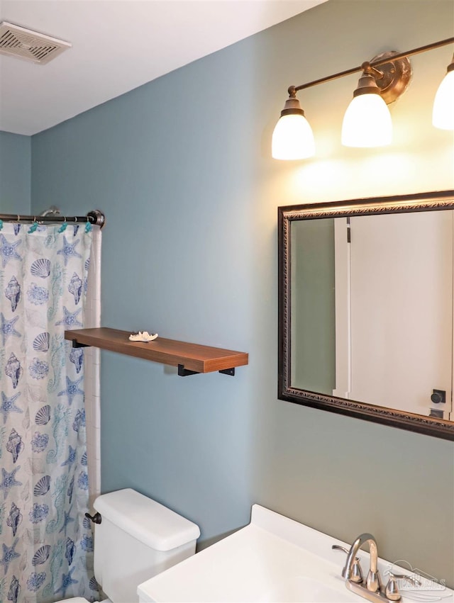 bathroom featuring vanity, toilet, and walk in shower