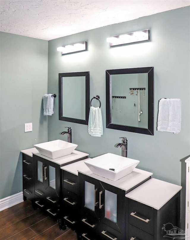 bathroom featuring vanity, wood-type flooring, and a textured ceiling