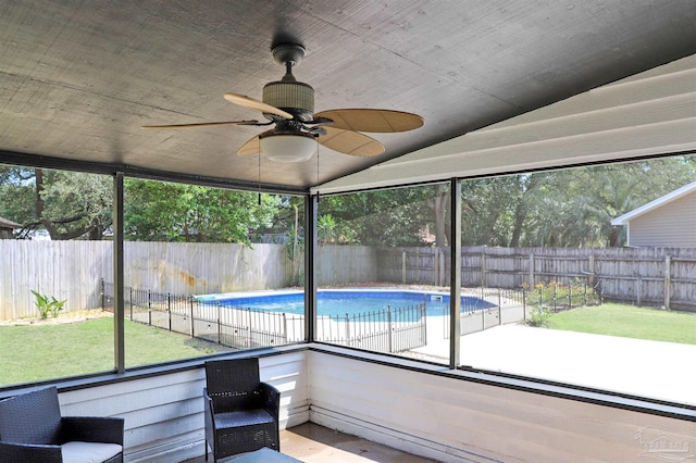 unfurnished sunroom featuring ceiling fan, vaulted ceiling, and a wealth of natural light