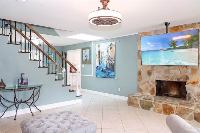 tiled living room featuring a stone fireplace