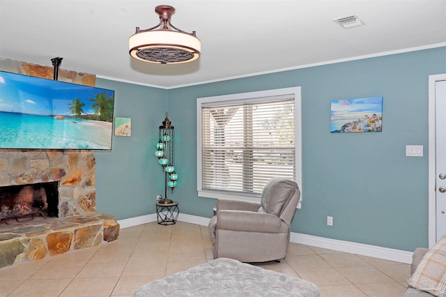 living area with crown molding, a fireplace, and light tile patterned floors