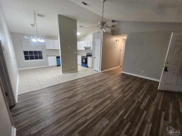 unfurnished living room featuring lofted ceiling, ceiling fan with notable chandelier, a textured ceiling, and light wood-type flooring