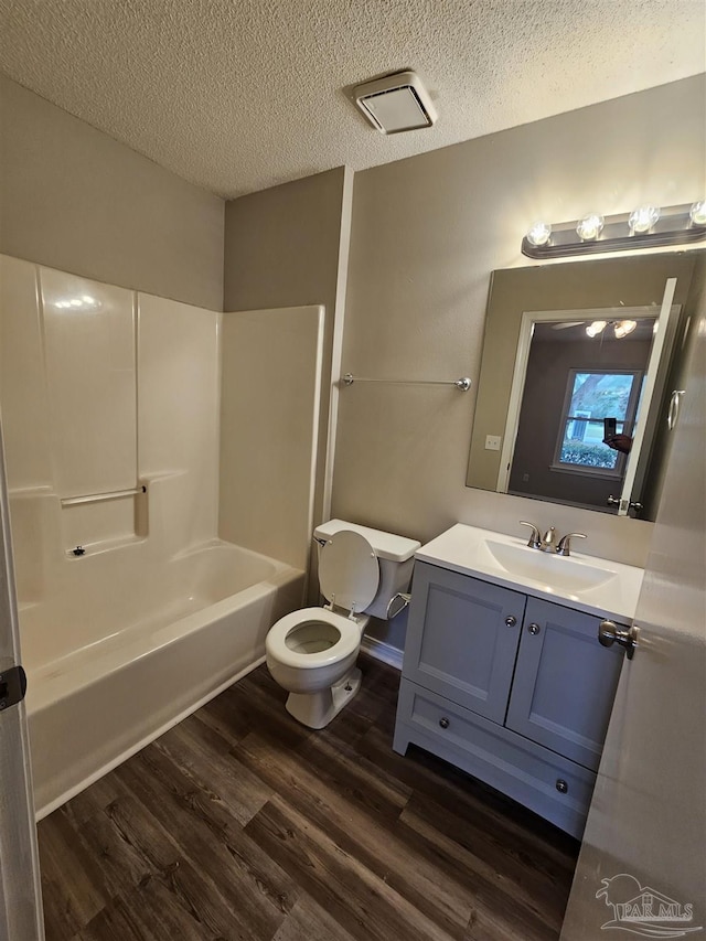 full bathroom with vanity, hardwood / wood-style floors, shower / washtub combination, and a textured ceiling