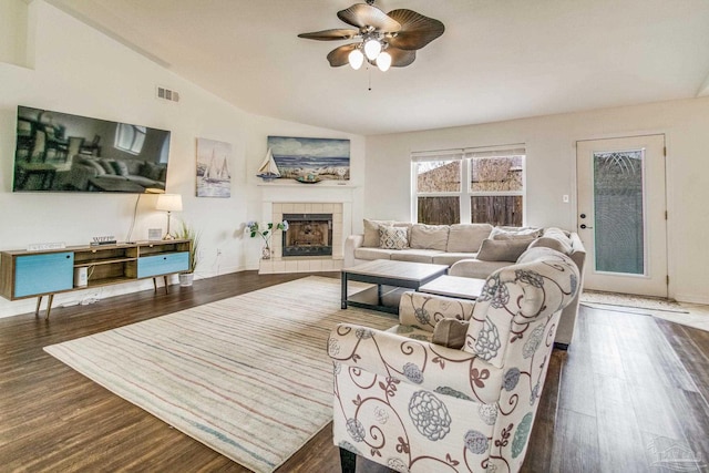 living room with a fireplace, dark wood-type flooring, vaulted ceiling, and ceiling fan