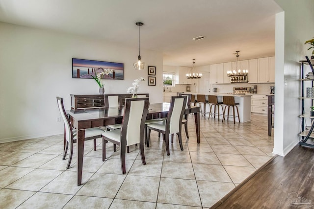 dining area featuring light tile patterned floors and an inviting chandelier