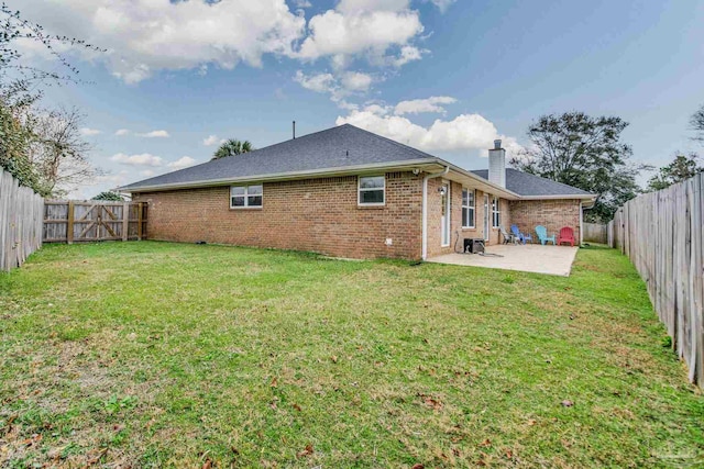 rear view of house with a patio area and a lawn