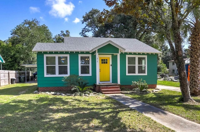 bungalow with roof with shingles, a front lawn, and fence