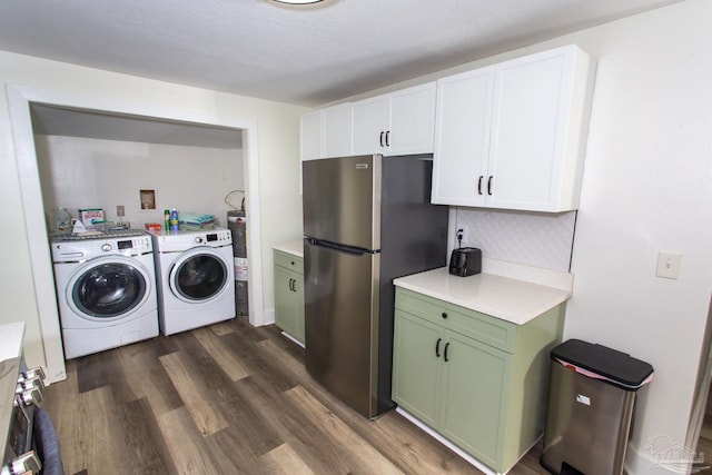 washroom with laundry area, washer and dryer, and dark wood-type flooring