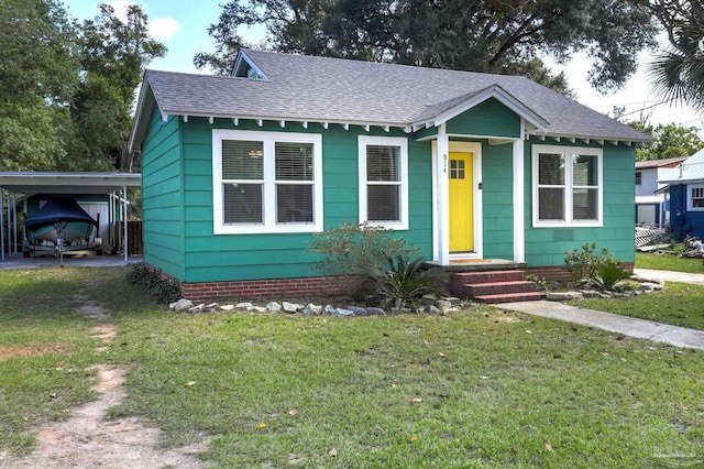 bungalow-style house with driveway, a carport, roof with shingles, and a front lawn