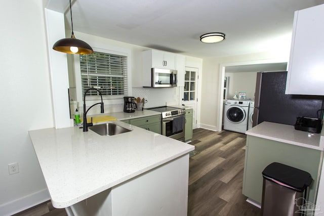 kitchen with a sink, tasteful backsplash, dark wood-style floors, washing machine and dryer, and appliances with stainless steel finishes