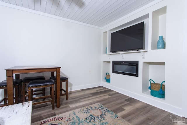 interior space featuring a glass covered fireplace, wooden ceiling, baseboards, and wood finished floors