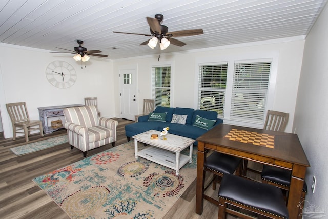 living area with ceiling fan, wood ceiling, wood finished floors, and ornamental molding