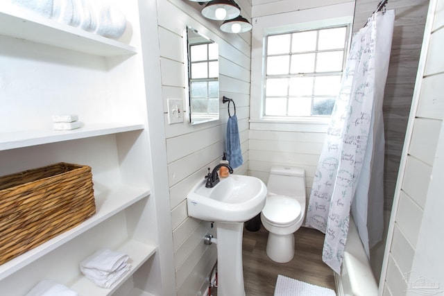 full bathroom with a shower with shower curtain, toilet, wood finished floors, and wood walls