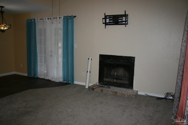 unfurnished living room featuring carpet and a brick fireplace