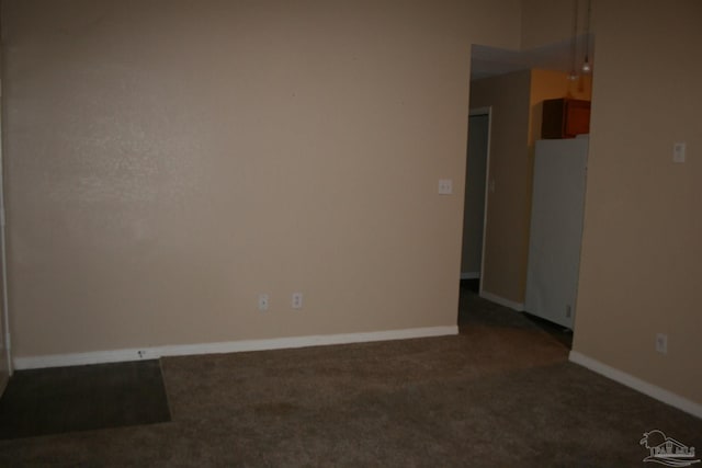 unfurnished room with dark carpet