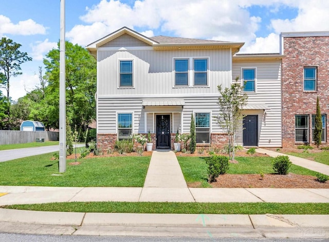 multi unit property with a front yard and board and batten siding