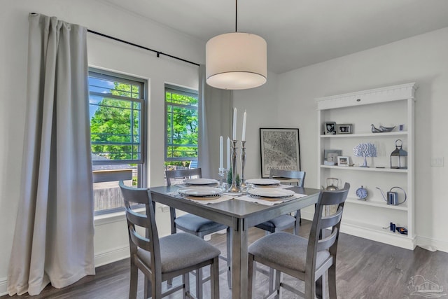 dining space featuring dark wood-style flooring and baseboards