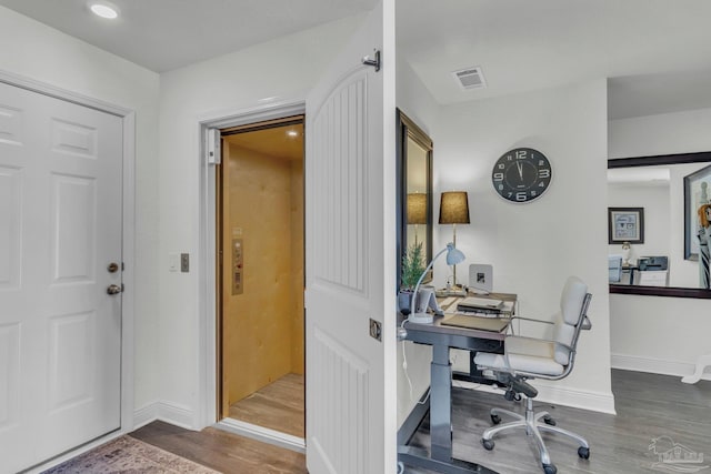 home office with visible vents, baseboards, and wood finished floors