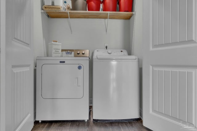laundry area featuring dark wood-type flooring, washer and clothes dryer, and laundry area