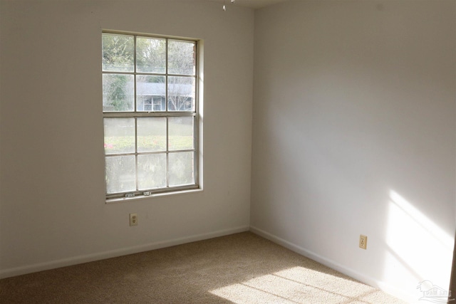 carpeted spare room featuring plenty of natural light