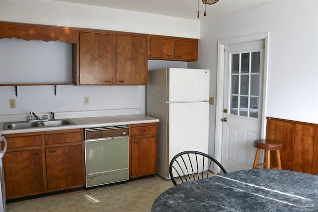 kitchen with light tile patterned floors, white fridge, dishwashing machine, and sink