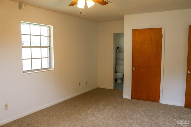 unfurnished bedroom with multiple windows, carpet, and ceiling fan