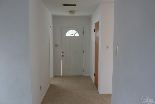 doorway to outside with light colored carpet