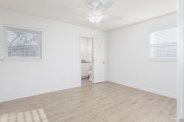 unfurnished bedroom featuring connected bathroom, multiple windows, ceiling fan, and light hardwood / wood-style flooring