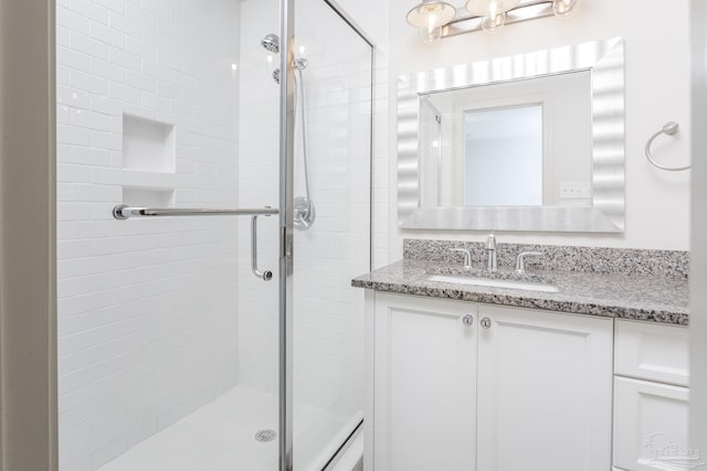 bathroom with walk in shower and vanity